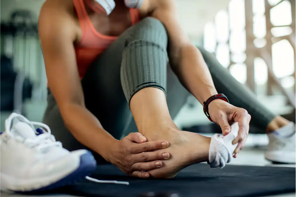 Persona deportista tocándose el tobillo por dolor o lesión, medicina del deporte y medicina integrativa para recuperación y prevención de lesiones.
