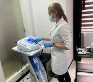 Profesional médica operando equipo de ozonoterapia durante tratamiento en clínica de medicina integrativa en Bogotá.