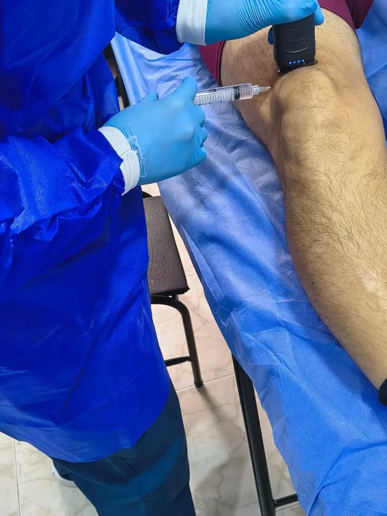 Médico especialista en Bogotá realizando infiltración articular ecoguiada para máxima precisión en la aplicación de células madre y exosomas.