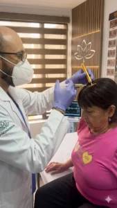Dr. Camilo en Vitaconciencia realizando el Protocolo RESET de neuromodulación avanzada con jeringa e instrumento de biorregulación para el tratamiento de fibromialgia y migraña en Bogotá.
